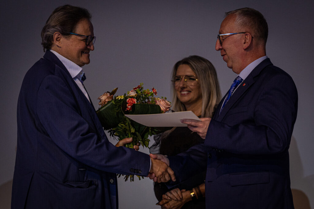 Zdjęcie. Radni Joanna Winiarska i Jarodław Bukowski wręczają nagrodę Andrzejowi Skorupskiemu.