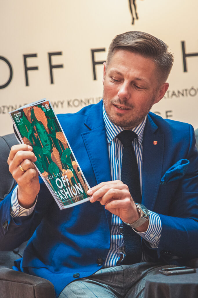 Zdjęcie. Wiceprezydent Kielc Marcin Chłodnicki pokazuje plakat konkursu OFF Fashion.