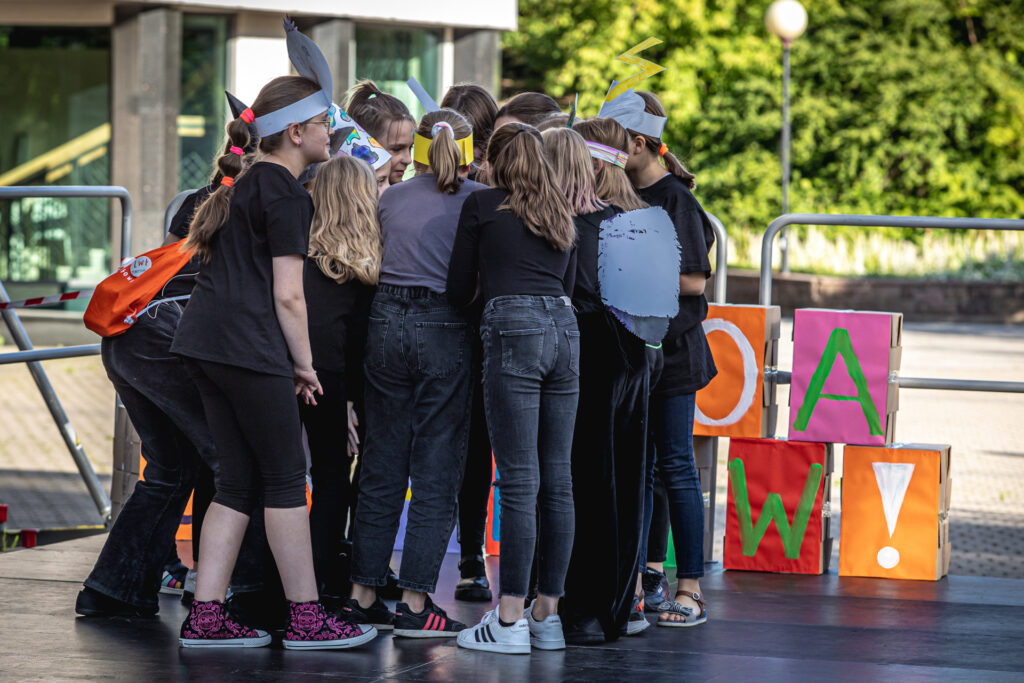 Zdjęcie. Duża grupa dzieci skupiona blisko siebie. Wyglądają, jakby się namawiali.