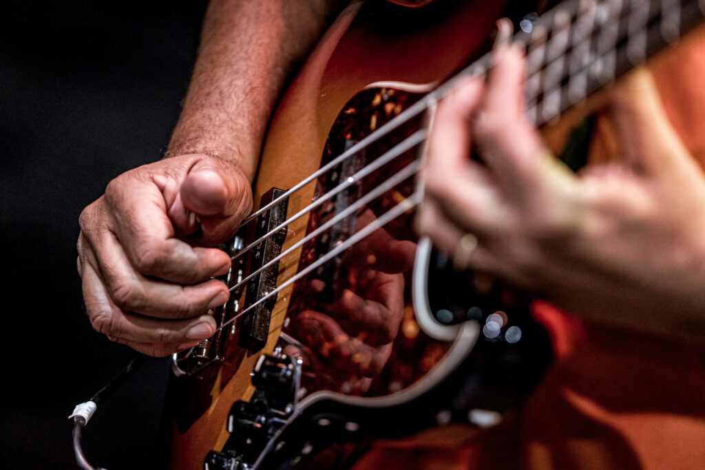 Zdjęcie. Zbliżenie na ręce grające na gitarze.