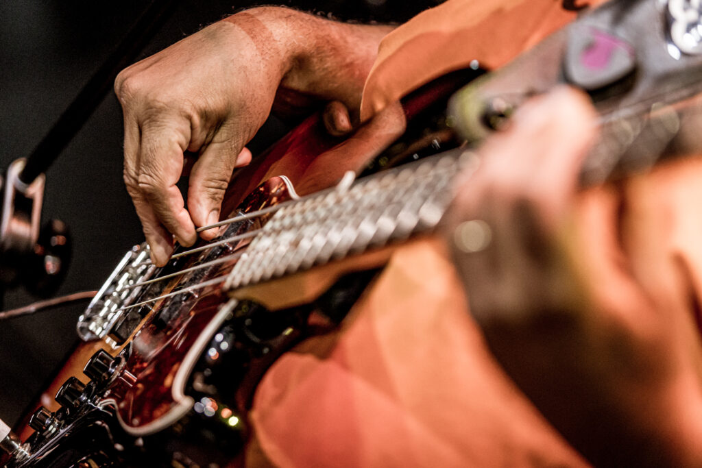 Zdjęcie. Zbliżenie na ręce grające na gitarze.