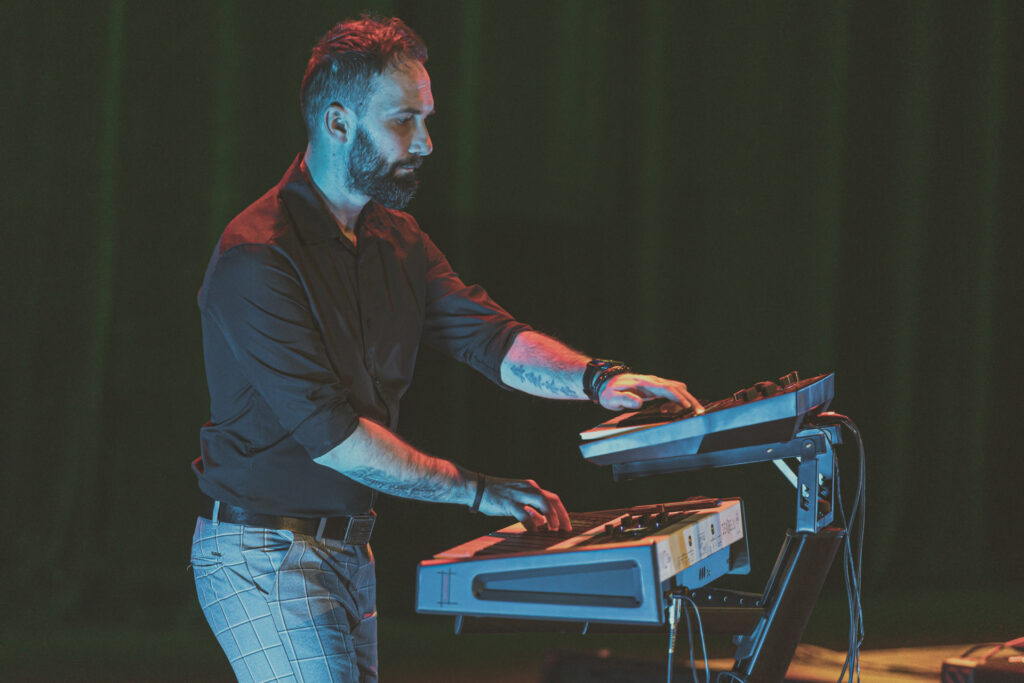 Zdjęcie. Mężczyzna gra na keyboardzie.