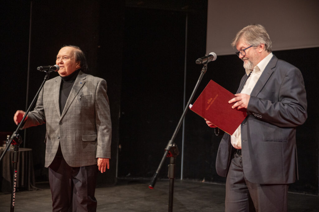 Zdjęcie. Dwaj panowie stoją przy mikrofonach. Na pierwszym planie kierownik impresariatu Robert Wieczorek, w tle pomysłodawca festiwalu Krzysztof Miklaszewski.