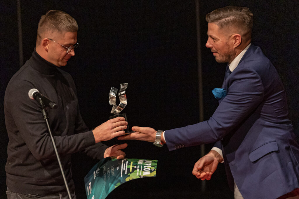 Zdjęcie. Wiceprezydent Marcin Chłodnicki wręcza statuetkę laureatowi festiwalu Nurt.