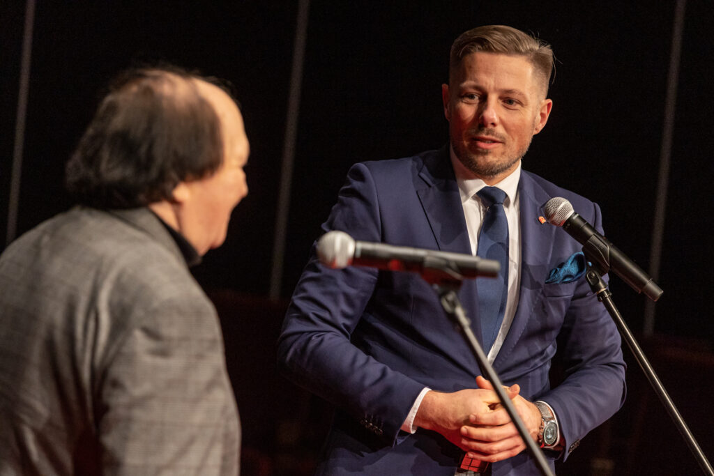 Zdjęcie. Wiceprezydent Marcin Chłodnicki mówi do mikrofonu. Patrzy w kierunku pomysłodawcy festiwalu Nurt, Krzysztofa Miklaszewskiego.