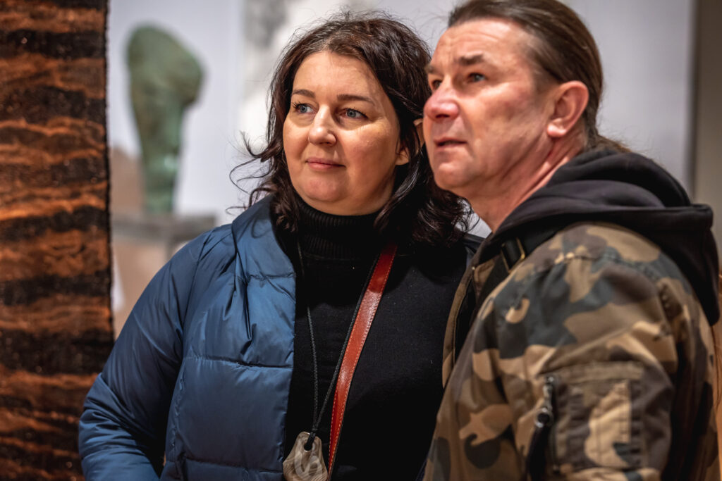 Zdjęcie. Dwójka ludzi: kobieta i męzczyzna stoją blisko siebie. Patrzą w jedynym kierunku.