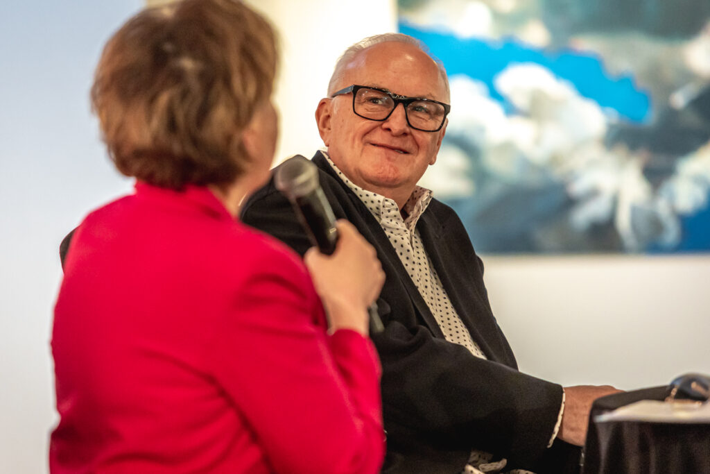 Jacek Cygan patrzy w kierunku Marzeny Sobali, która mówi coś do mikrofonu.