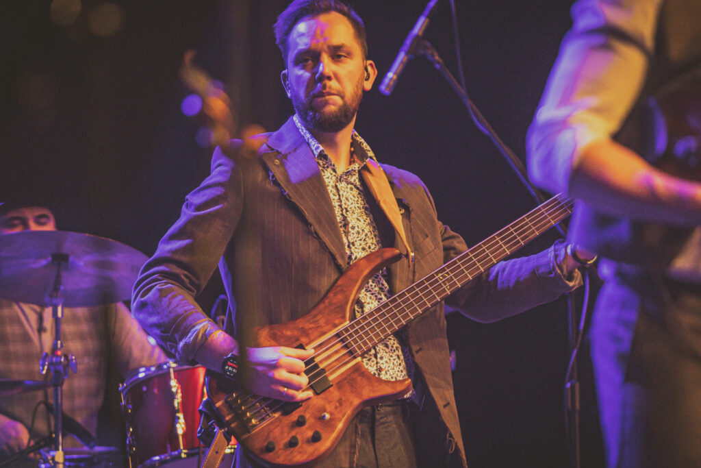 Zdjęcie. Muzyk Zespołu Zakopower gra na gitarze.