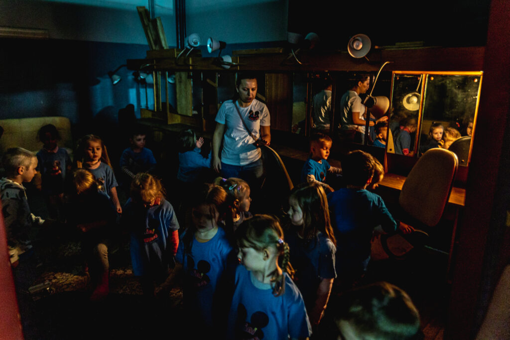 Zdjęcie. Dzieci gromadzą się przy lustrach garderób w kieszeni Dużej Sceny KCK.