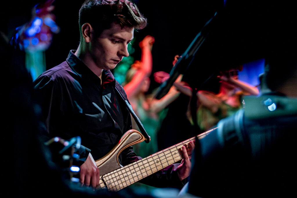 Zdjęcie. Mlody chłopak gra na gitarze na scenie KCK.
