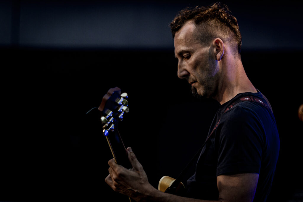Zdjęcie. Gitarzysta gra na letniej scenie kck.