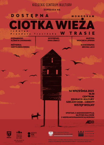 Grafika. Plakat spektaklu. Na czerwonym tle wąski czarny domek ze spadzistym dachem na patyczakowatych, prostych nogach. Obok czarny. pies. Na górze napisy: Kieleckie Centrum Kultury zaprasza na : Dostępna Ciotka Wieża. Monodram w trasie. 14 września 2014 godz. 18 Centrum Edukacji i Kultury Szklany Dom - Ciekoty, wstęp wolny. Spektakl z audiodeskrypcją na żywo dla osób z niepełnosprawnością wzroku.