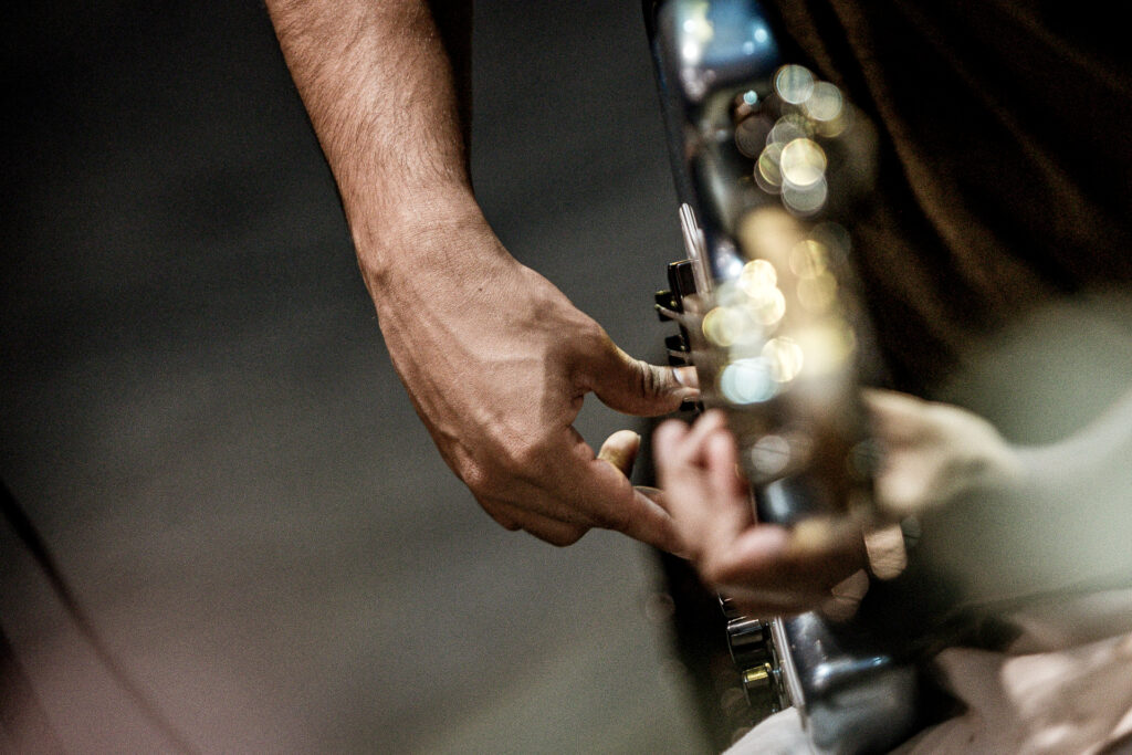 Zdjęcie. Dłoń grająca na gitarze.