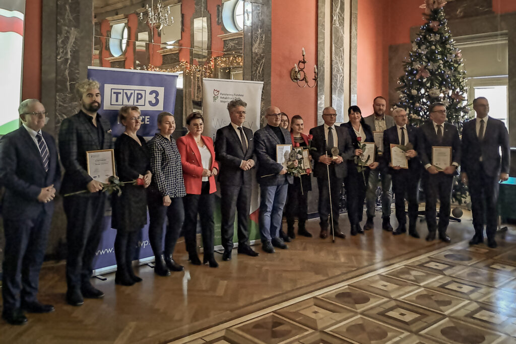 Zdjęcie. Laureci nagród i wyróżnień pozują w rzędzie do fotografii.