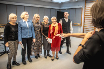 Zdjęcie. Aktorzy Teatru bez Suflera stoją w rzędzie. Od lewej: Renata, Iwona, Monika, Zofia, Ela i Zygmunt. Przed nimi prowadząca Jolanta Kęćko.