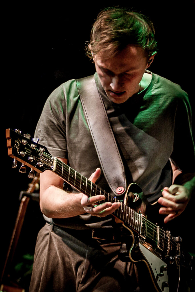 Zdjęcie. Koncert Podsłuchy. Wokalista grupy Patrick the Pan gra na gitarze.
