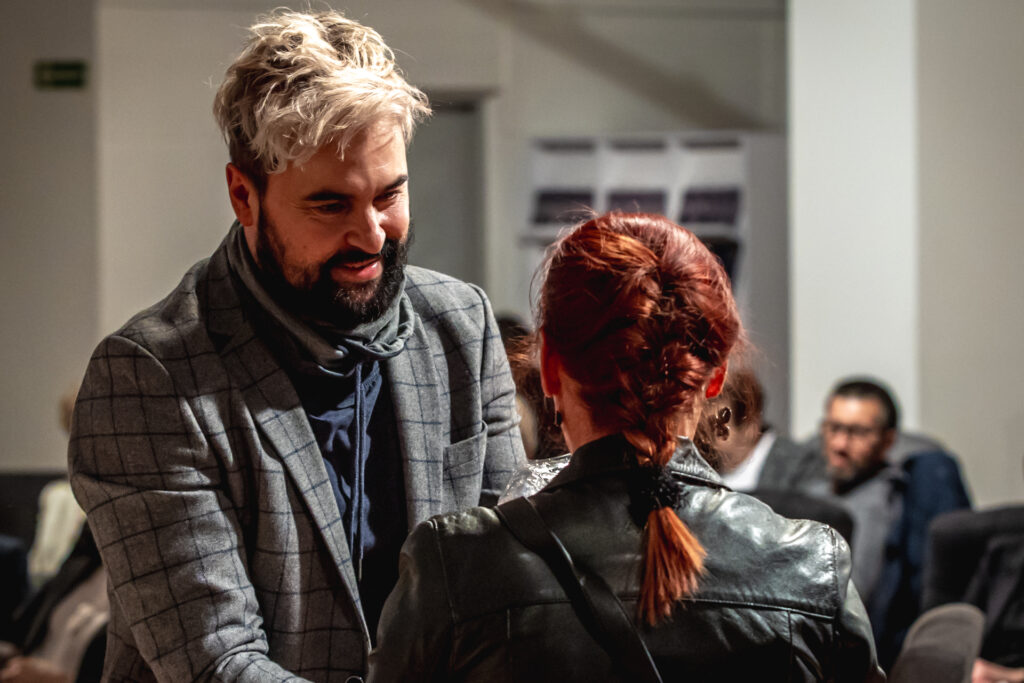 Zdjęcie. Wicedyrektor Artur Wijata pochyla się w kierunku kobiety o kasztanowych włosach spiętych w warkocz.