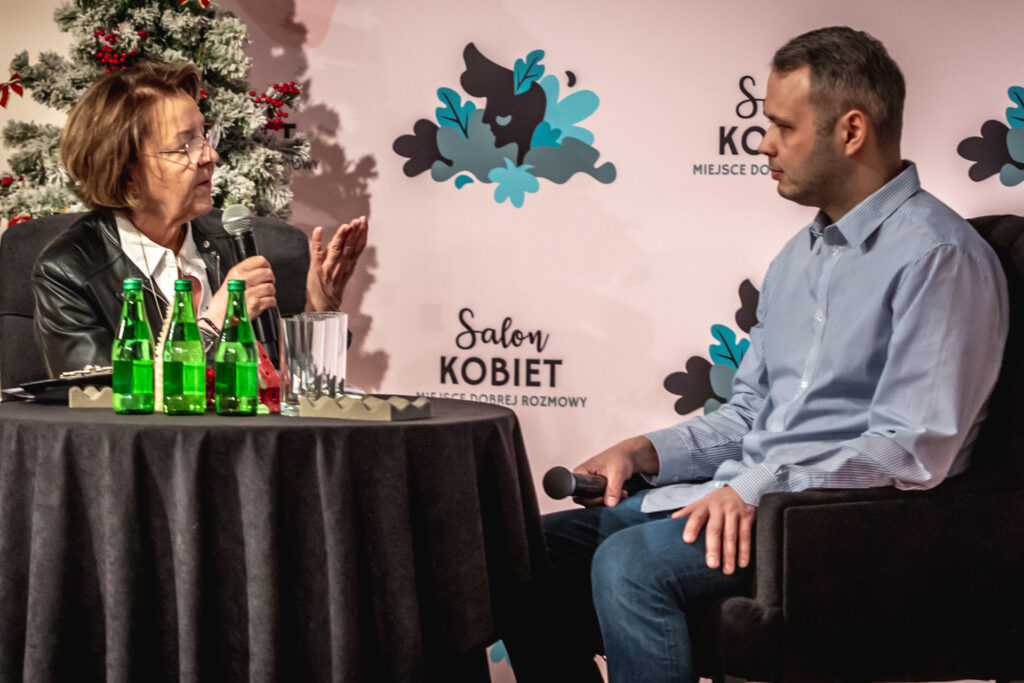 Zdjęcie. Dwie osoby: kobieta i mężczyzna rozmawiają przy stoliku . To Marzena Sobala, prowadząca Salon Kobiet i jej gość, lekarz Jakub Sieczko.