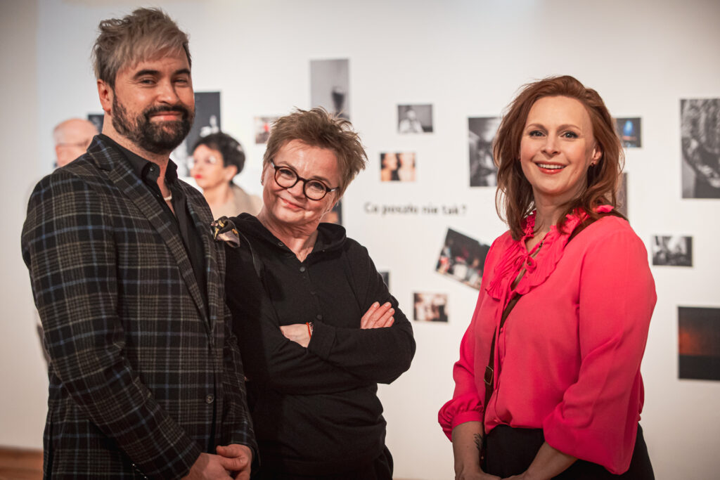 Zdjęcie. Trójka ludzi pozuje do fotografii. Od lewej: mężczyzna w marynarce w kratce z blond grzywką zaczesaną na bok. To Artur Wijata. Obok niewysoka kobieta z krótkimi włosami podniesionymi do góry i w okularach o ciemnych oprawkach. To prezeska Polish Women Photograpgy Malgorzata Wakuluk. Obok uśmiechnięta kobieta w intensywnie różowej bluzce. To Paulina Holtz.