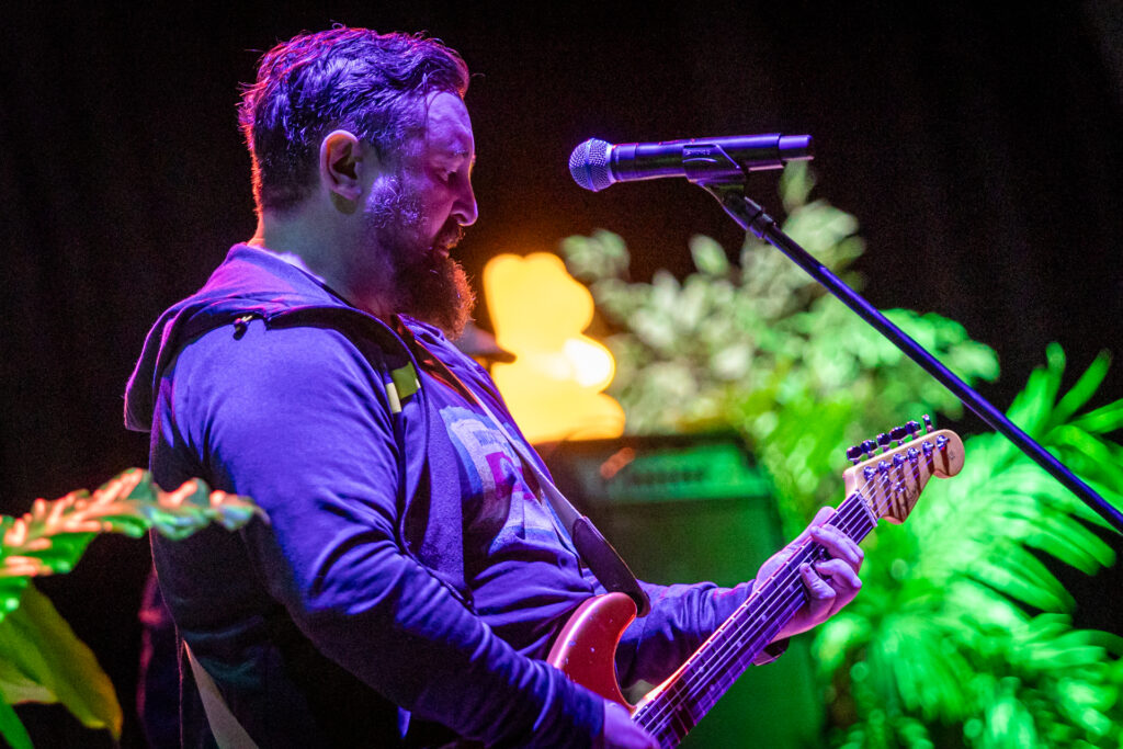 Zdjęcie. Gruby mężczyzna z długa brodą w bluzie z kapturem gra na gitarze. to muzyk zespołu Hurt.