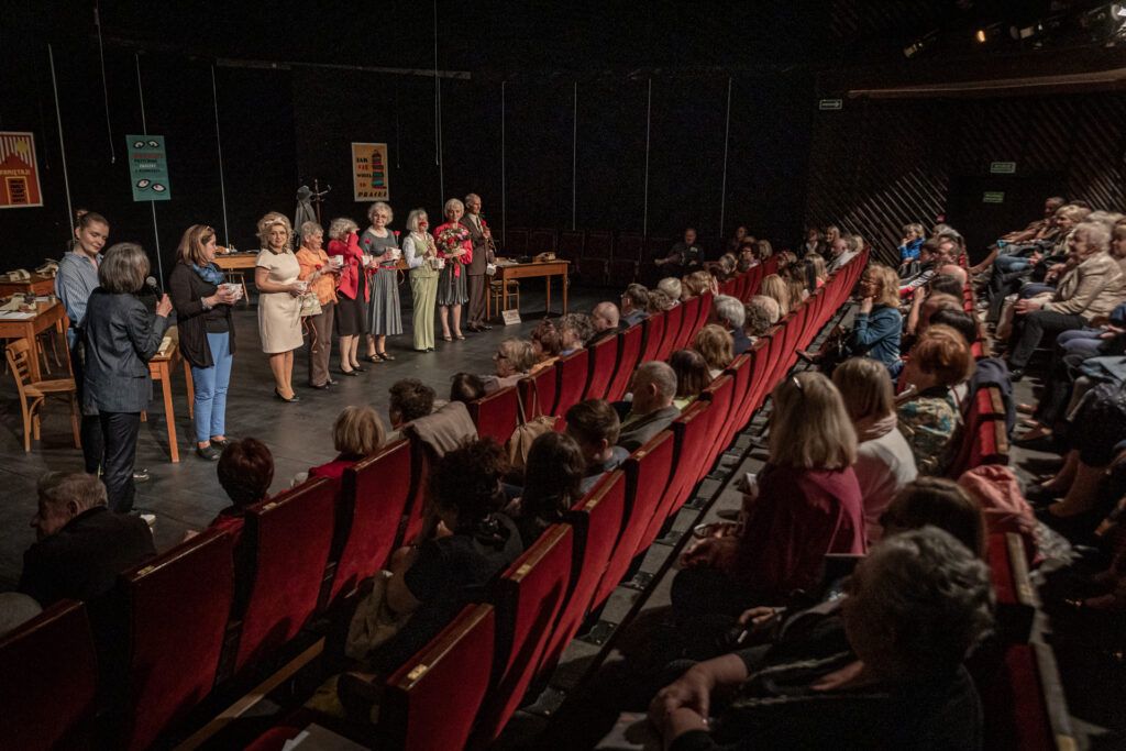 Zdjęcie. Ekipa Teatru bez Suflera stoi na brzegu sceny. Przed nimi pełna widownia Małej Sceny KCK.