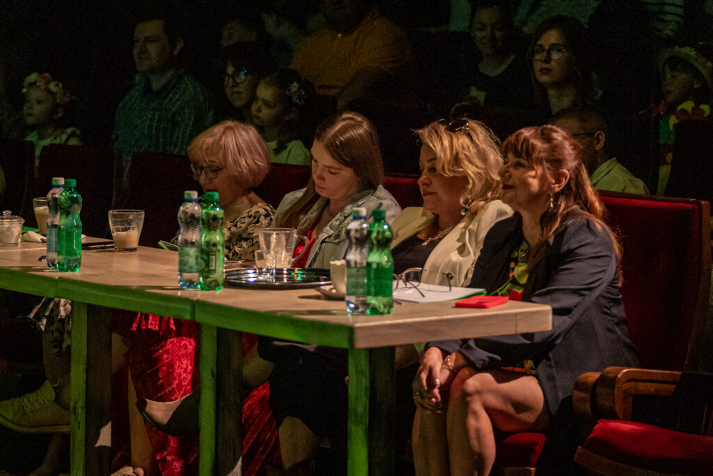 Zdjęcie. Cztery kobiety siedzą za stołem w pierwszym rzędzie Małej Sceny KCK. To jury konkursu "Piosenka-Wiosenka".