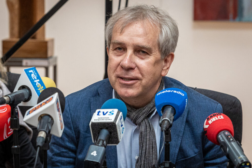 Zdjęcie. Mężczyzna o siwych włosach z uśmiechem mówi do mikrofonu. To Jarosław Gajewski, dyrektor Teatru Klasyki Polskiej.