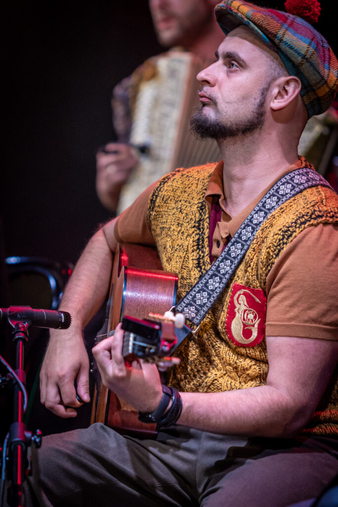 Zdjęcie. Muzyk Warszawskiego Combo Tanecznego gra na gitarze.