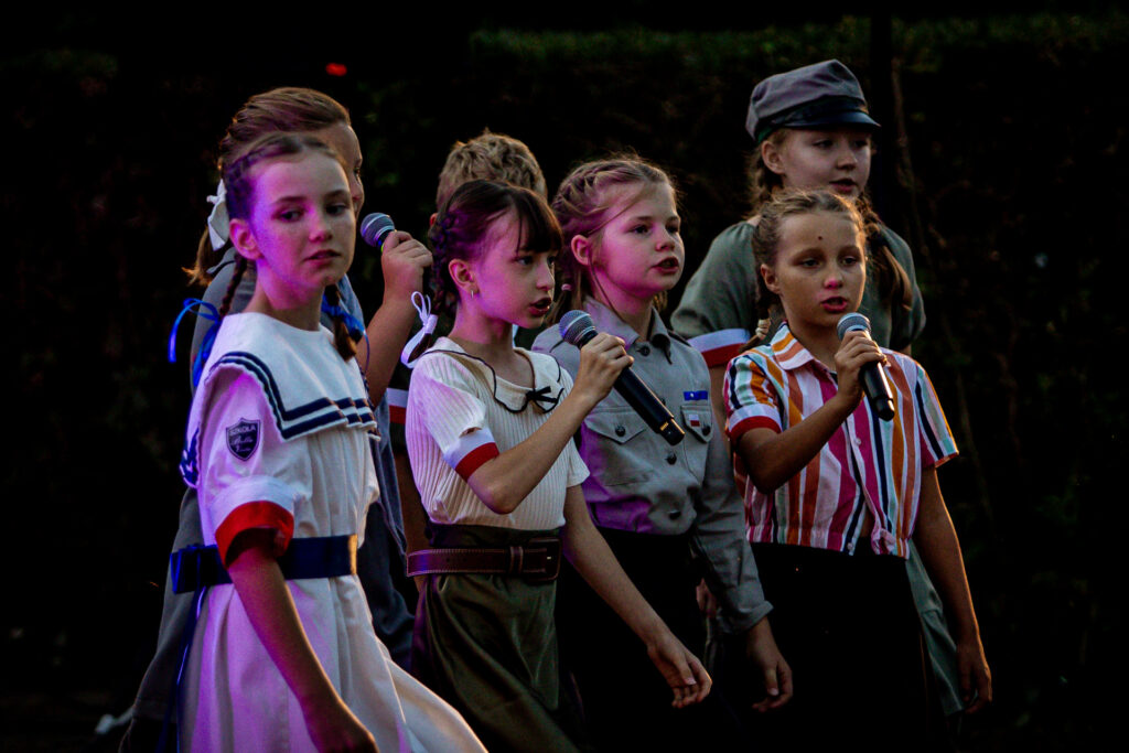 Zdjęcie. Grupa dzieci. śpiewa do mikrofonów.