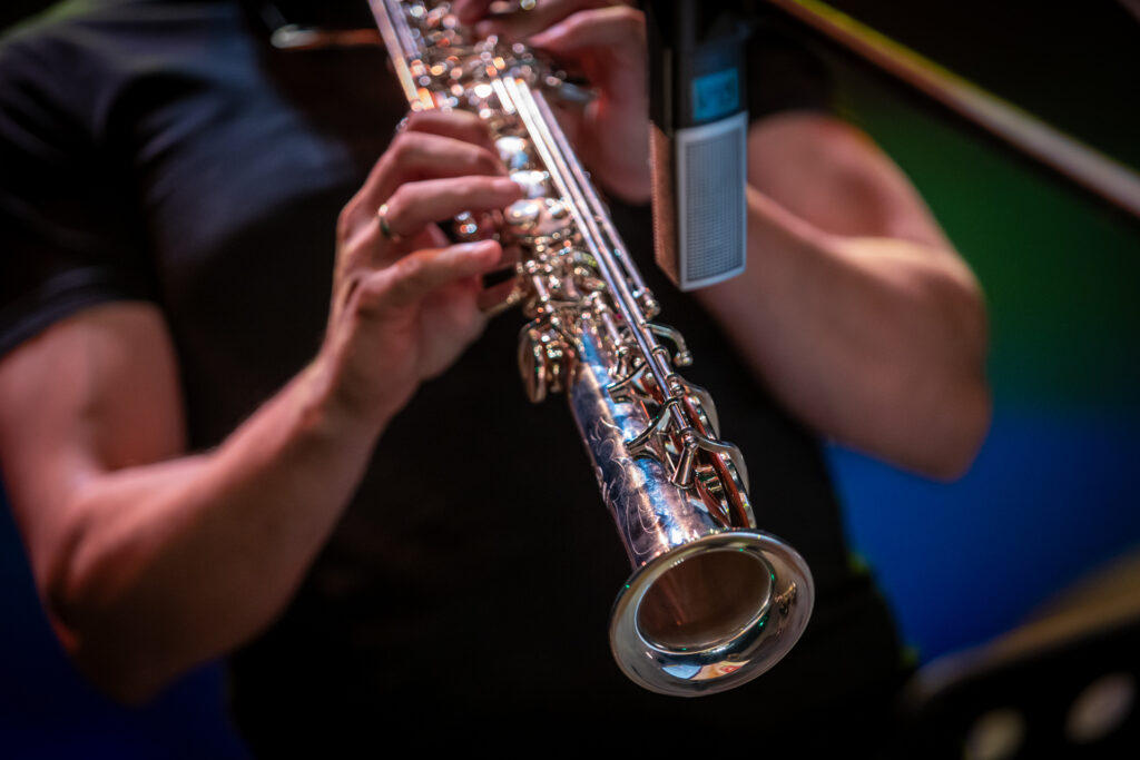 Zdjęcie. Tuba instrumentu metalowego dętego. Męskie dłonie, które naciskają klawisze instrumentu.