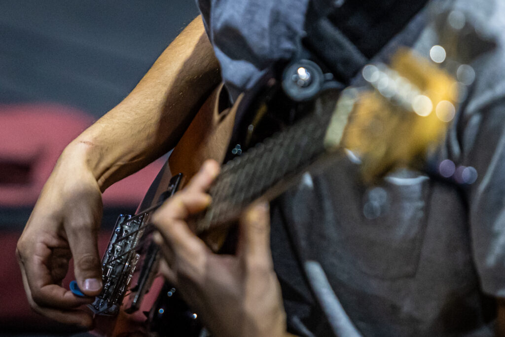 Zdjęcie. Dłonie mężczyzny grającego na gitarze.