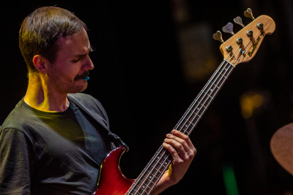 Zdjęcie. Ciemnowłosy mężczyzna z wąsami gra na gitarze.