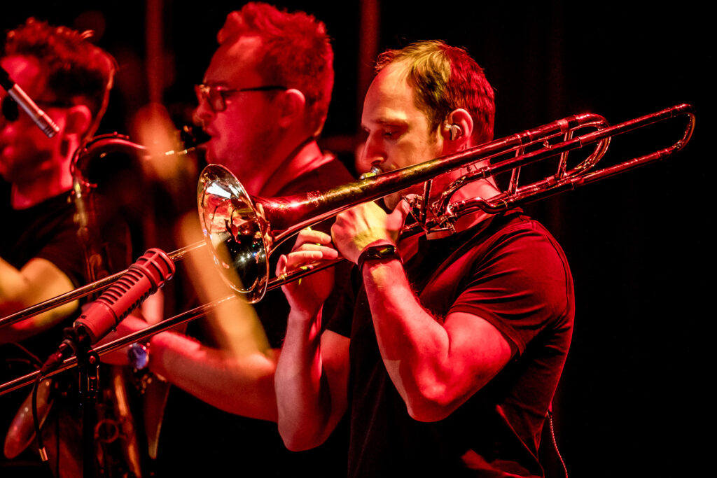 Zdjęcie. Dwóch muzyków gra na blaszanych instrumentach dętych.