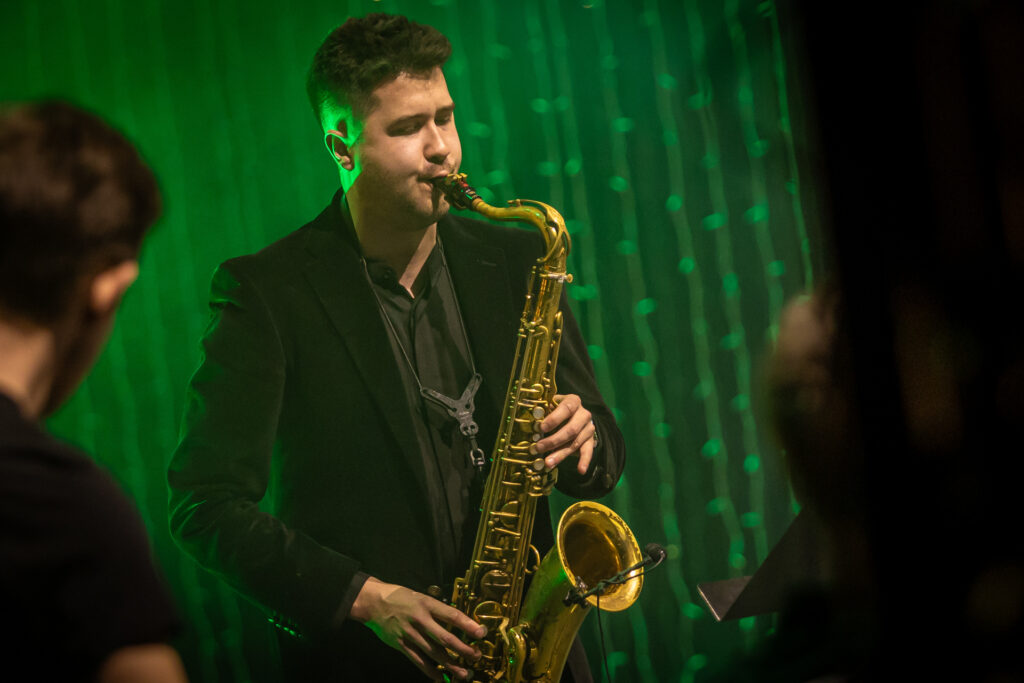 Zdjęcie. Saksofonista gra na instrumencie.