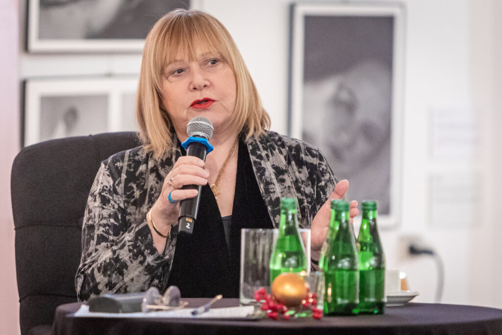 Zdjęcie. Joanna Żółkowska mówi do mikrofonu.