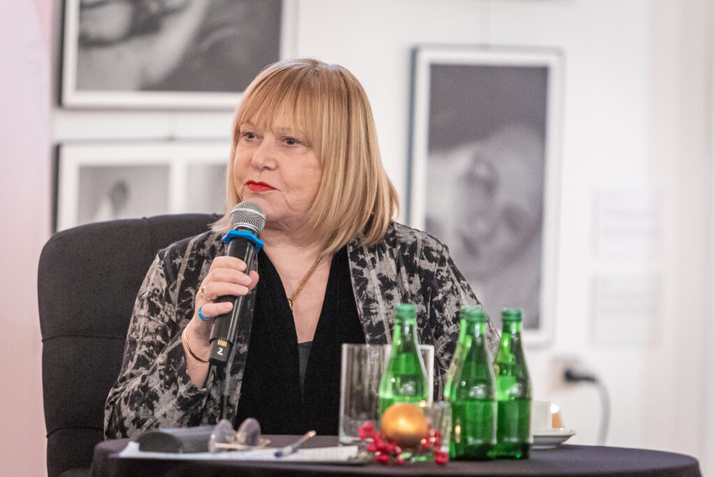Zdjęcie. Joanna Żółkowska mówi do mikrofonu.