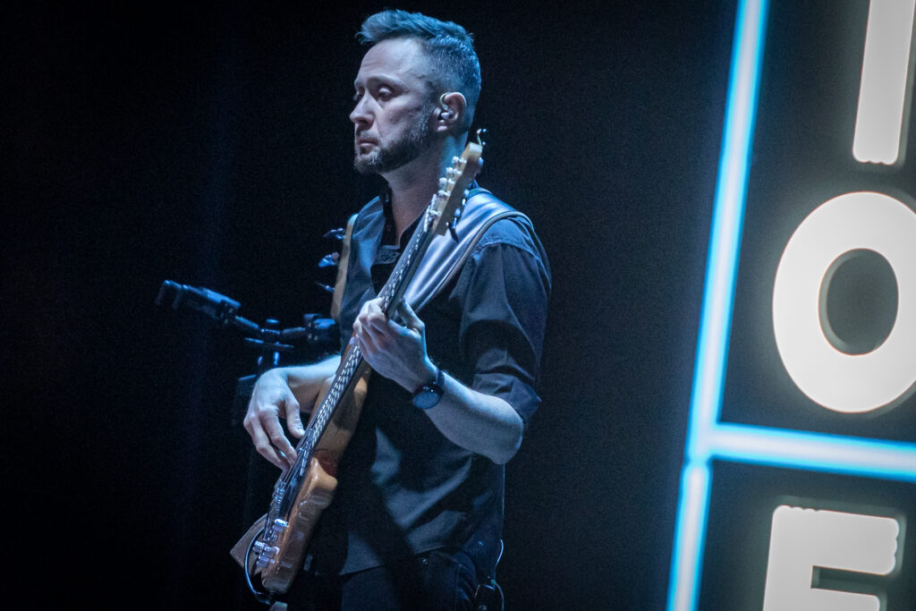Zdjęcie. Szczupły mężczyzna gra na gitarze.