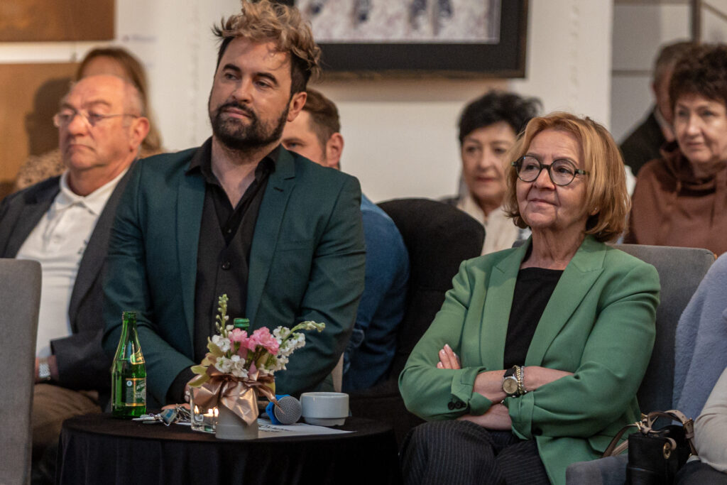 Zdjęcie. Dwie osoby siedzą przy okrągłym stoliku. To dziennikarka Marzena Sobala i dyrektor KCK Artur Wijata.