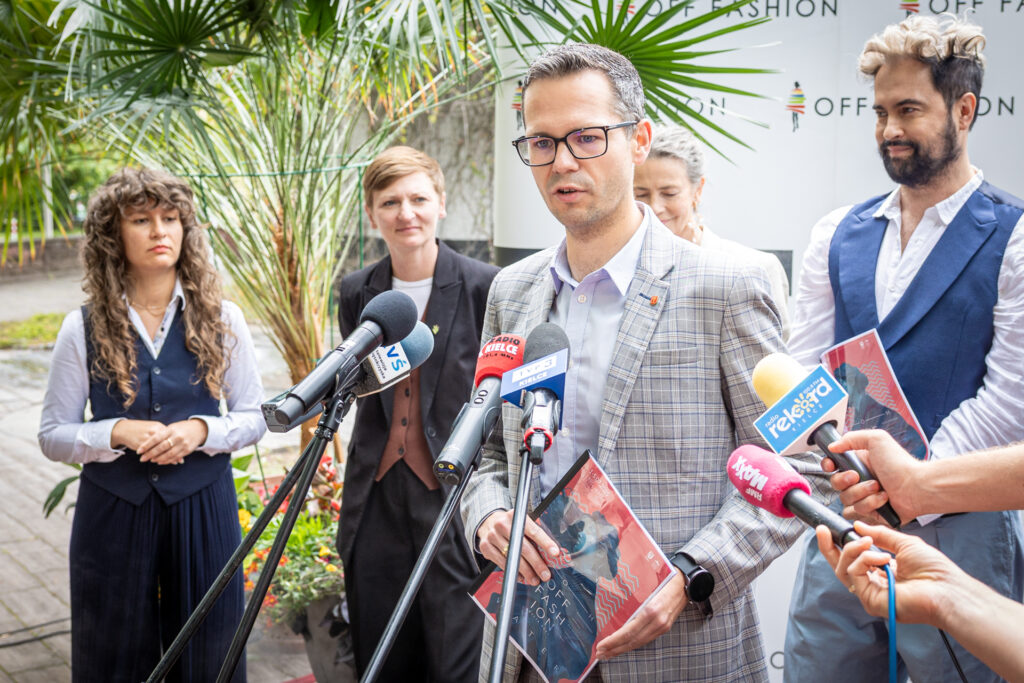 Zdjęcie. Wiceprezydent Kielc Tomasz Porębski mówi do mikrofonów podczas konferencji prasowej poświęconej OFF Fashion.